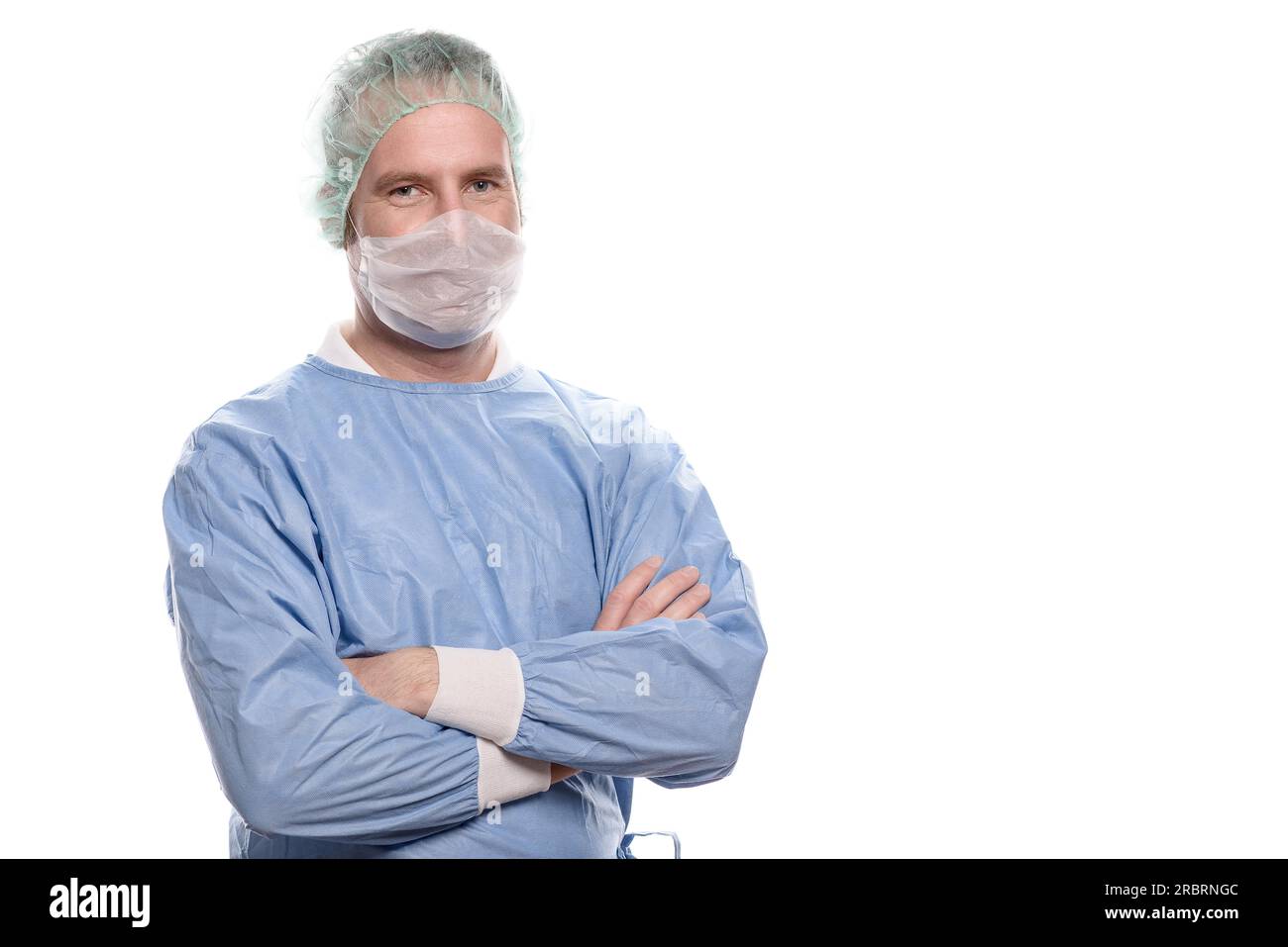 Freundliche Krankenschwester oder Arzt in chirurgischen Peelings, die ein Theaterkleid, eine Maske, eine Brille und eine Kappe tragen, die direkt auf die Kamera, den Kopf und die Schultern blickt Stockfoto