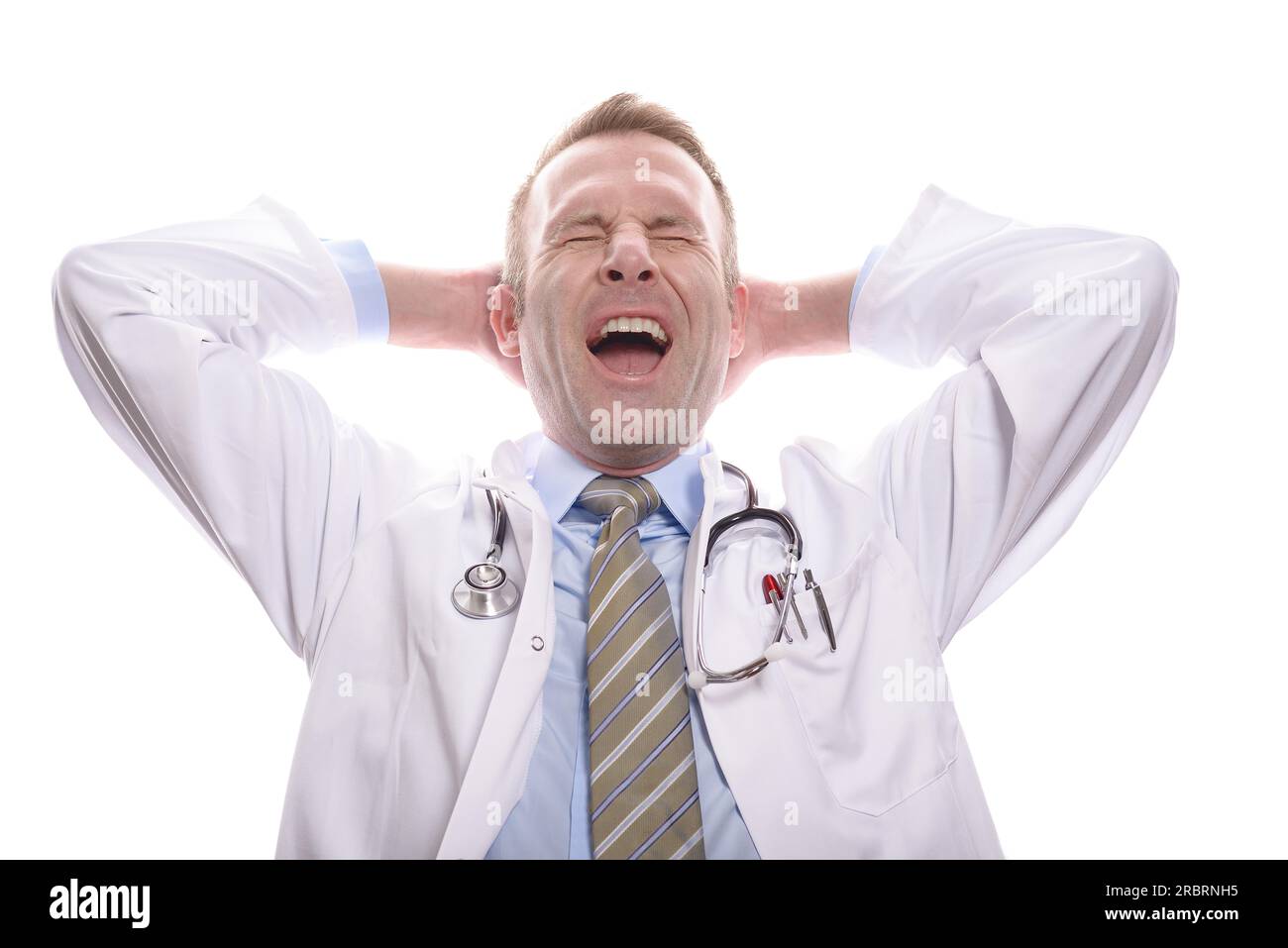 Zufriedener erfolgreicher Arzt entspannt mit geschlossenen Augen, seiner Hand hinter dem Kopf und einem intensiven Gähnen, isoliert auf weiß Stockfoto