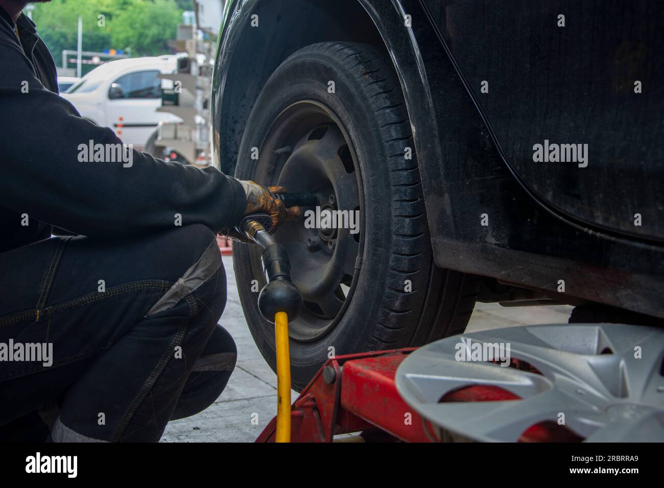 Reifenwechsel durch ein unbekanntes Gesicht im Autodienst Stockfoto