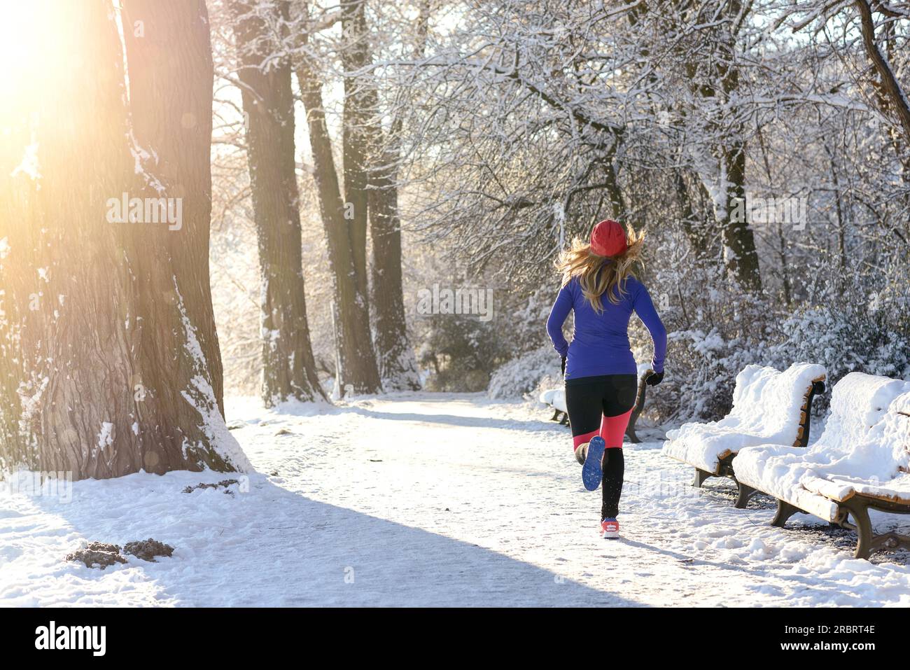 Rückansicht des jungen Frau Joggen im Winterthrough eine herbstliche Wald in einem gesunden, aktiven Lebensstil-Konzept Stockfoto