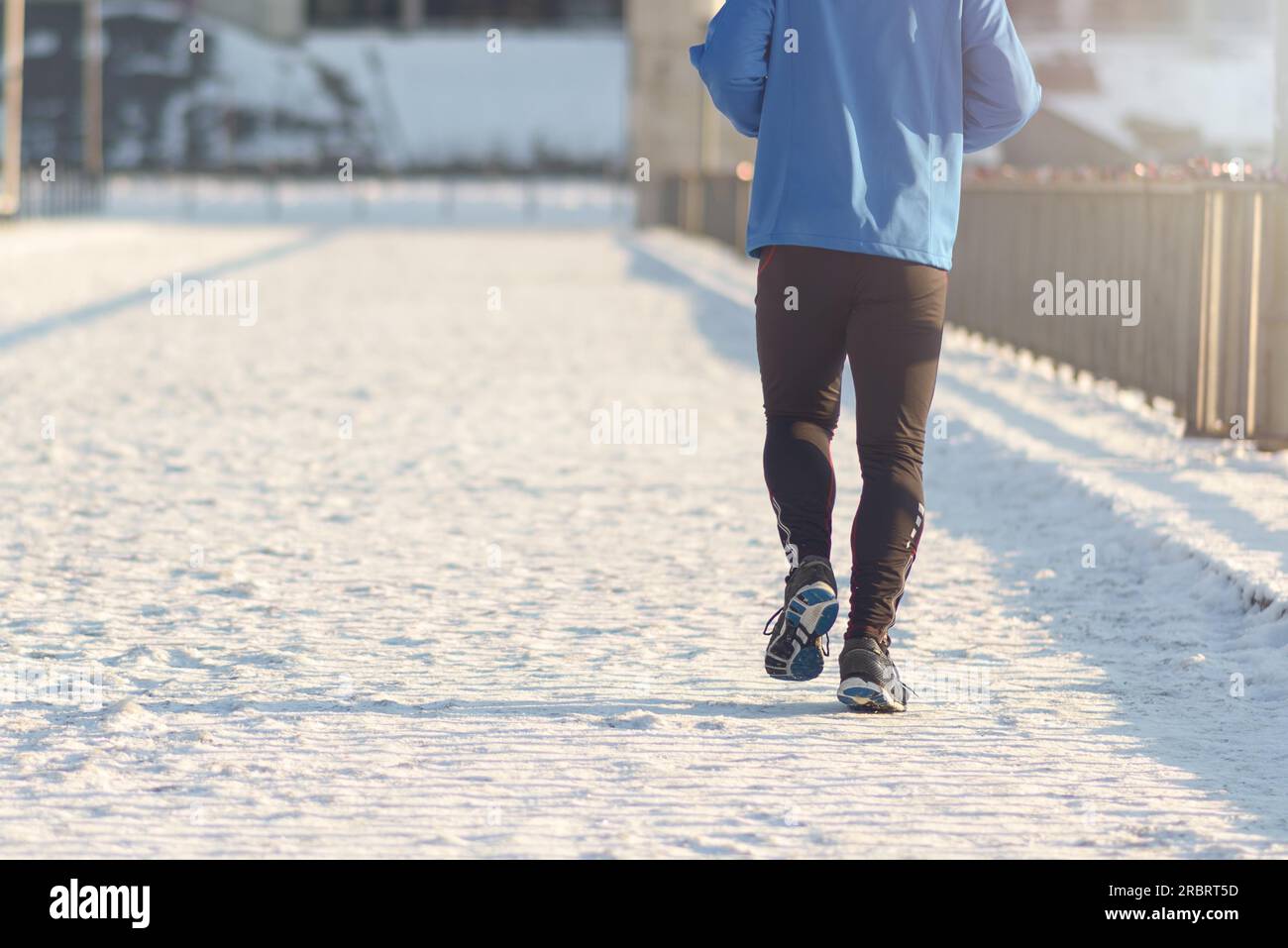 Rückansicht des Mann mittleren Alters, Joggen auf einer Strandpromenade in einem gesunden, aktiven Lebensstil-Konzept Stockfoto