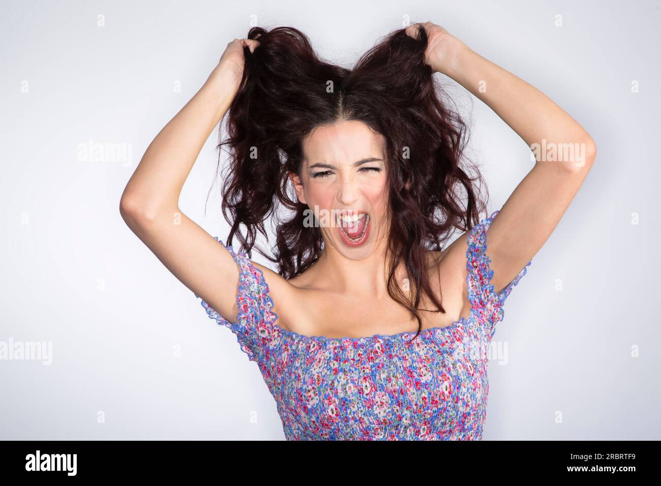 Ein dunkelhaariges Model, das schreit und Gefühle zeigt Stockfoto
