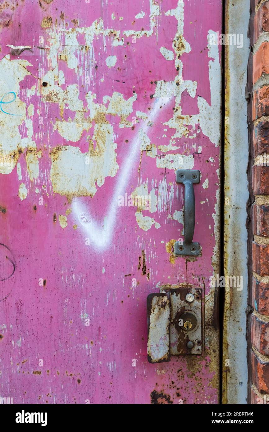 Graphiti auf einer verlassenen Tür in einer Stadtumgebung Stockfoto