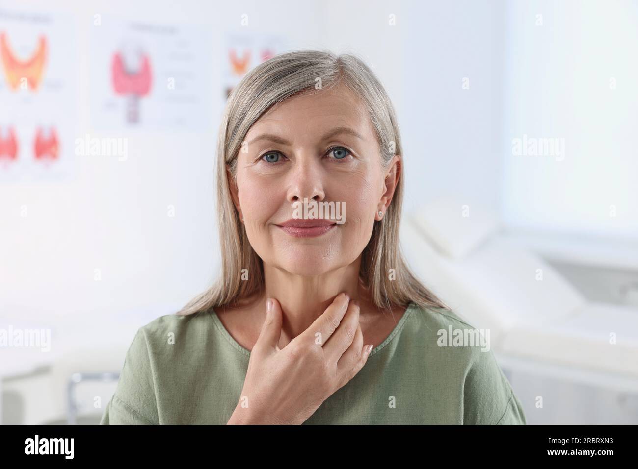 Endokrines System. Seniorin, die sich im Haus einer Schilddrüsen-Selbstuntersuchung unterzieht Stockfoto