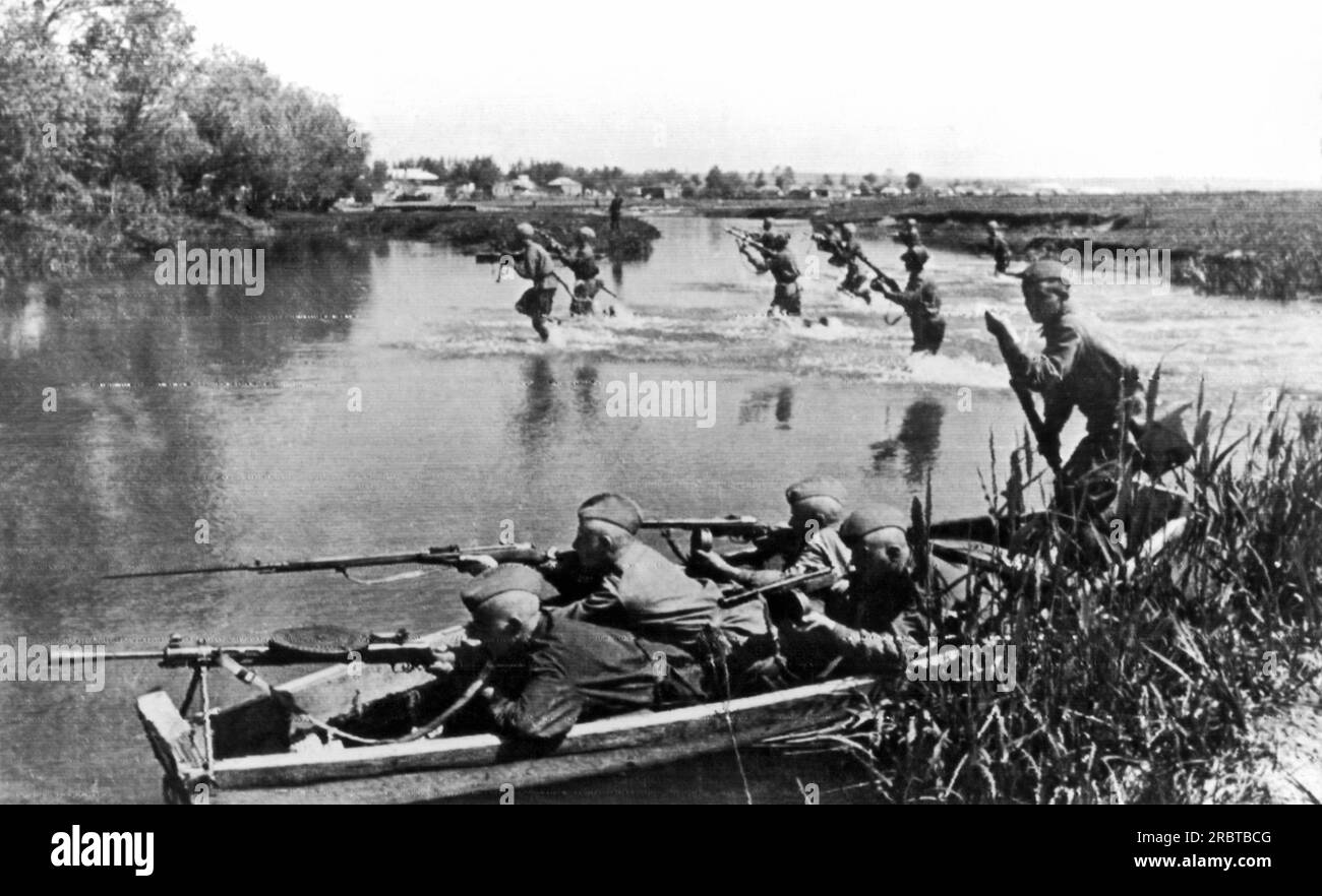Donets, Russland: 30. Mai 1943. Soldaten der Roten Armee, die in ihrem Boot krabbeln, decken den Vormarsch ihrer Späher ab, während eine Aufklärungstruppe einen Fluss in der Ukraine überquert. Stockfoto