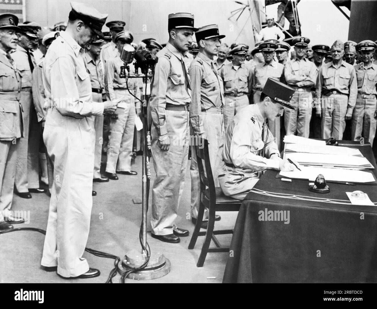 Tokio, Japan: Am 1. September 1945 mit weiteren französischen Delegierten hinter ihm signiert der französische General Jacques Le Clerc während der japanischen Kapitulationszeremonie an Bord der USS Missouri in der Bucht von Tokio nach Frankreich. USA General der Armee Douglas MacArthur steht links neben dem Mikrofon. Stockfoto