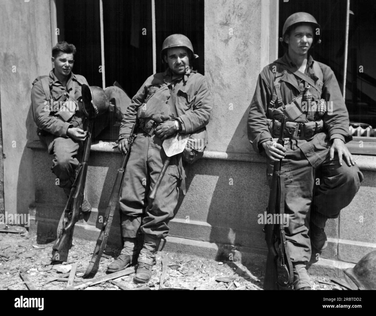 Villedieu, Frankreich, 4. August 1944 Pvt Charles E. Frady, Rocky Mount, North Carolina, Asst SQD LDR Raymond E. Taber, St. Louis, Missouri und PFC John R. Garstrom, Jamestown, New York, machen eine kurze Pause während einer Yank Infanterie Fahrt im Dorf Villedieu. Stockfoto