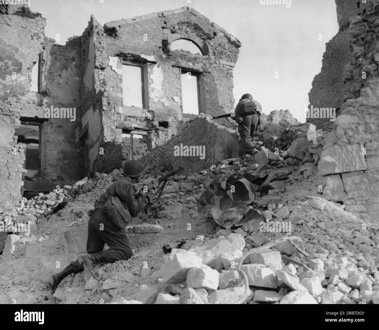 Bretagne, Frankreich 17. Juni 1944 Mitglieder einer Ingenieureinheit, die durch die Ruinen der bombardierten Gebäude in der Bretagne, Frankreich, unterwegs sind Stockfoto