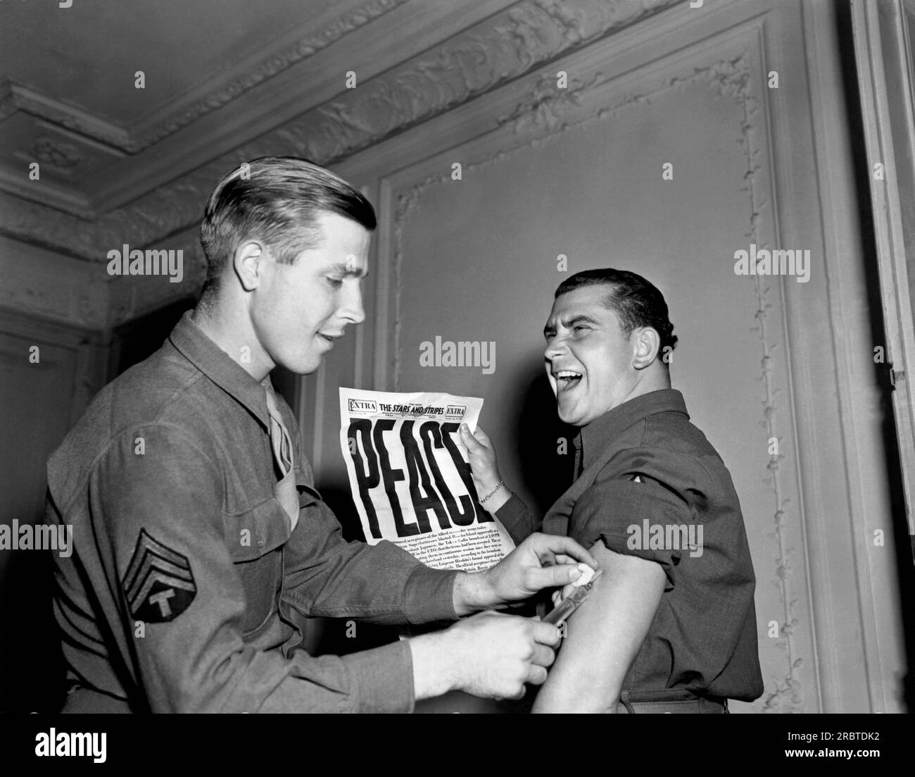 Paris, Frankreich: 14. August 1945 In den USA Der Soldat der Armee in Paris hat die neueste Ausgabe von The Stars and Stripes, in der die Kapitulation Japans mit der Schlagzeile "FRIEDEN" angekündigt wird. Stockfoto