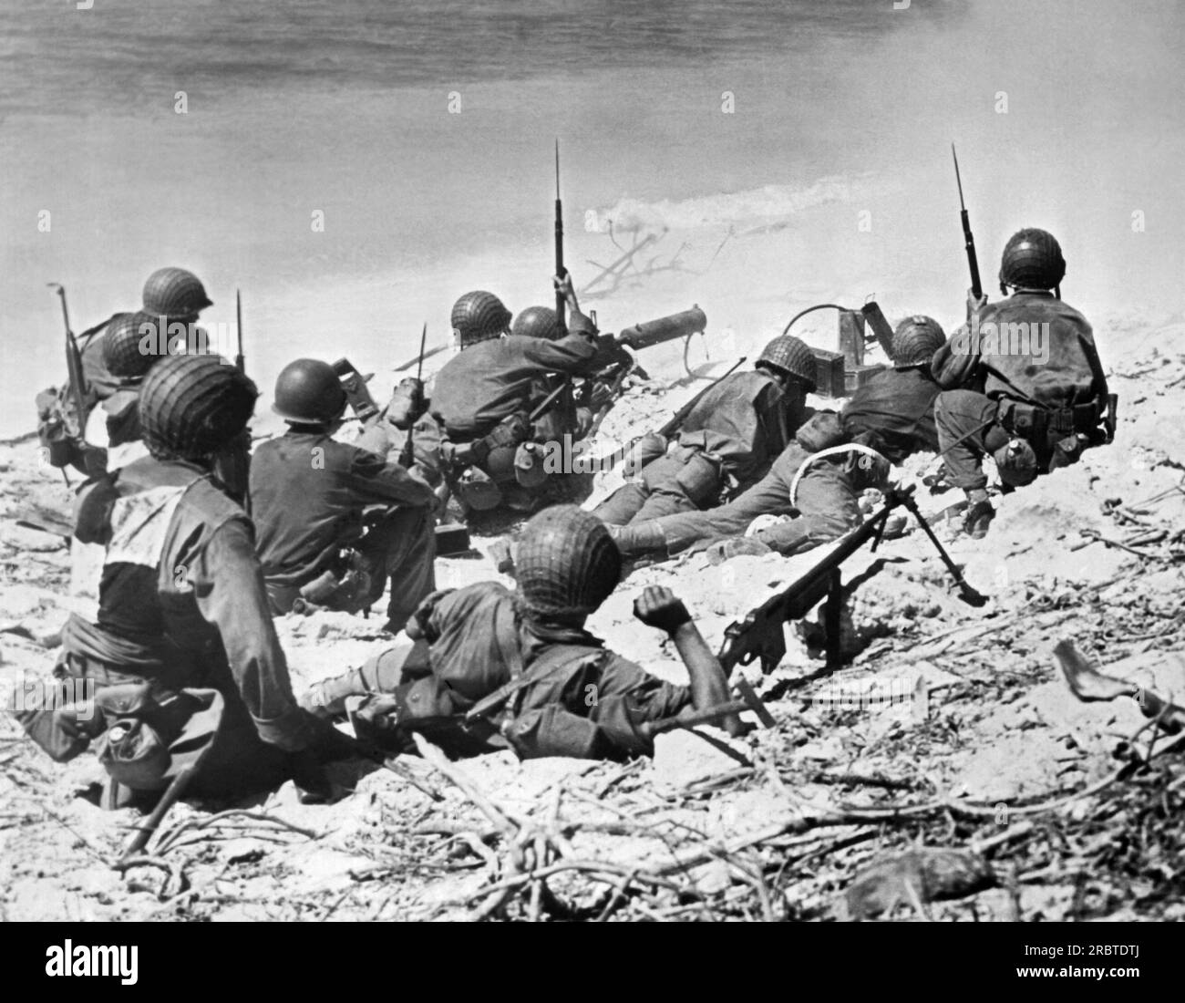 Marshallinseln: 11. August 1944, USA In der Eröffnungsphase der Invasion von Eniwetok Atoll decken sich Marines hinter Sanddünen. Stockfoto