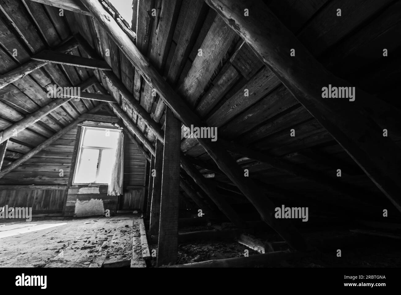 Abstraktes dunkles Grunge-Holz-Interieur, Ausblick auf einen verlassenen Dachboden mit leuchtenden Fenstern, Schwarz-Weiß-Foto Stockfoto