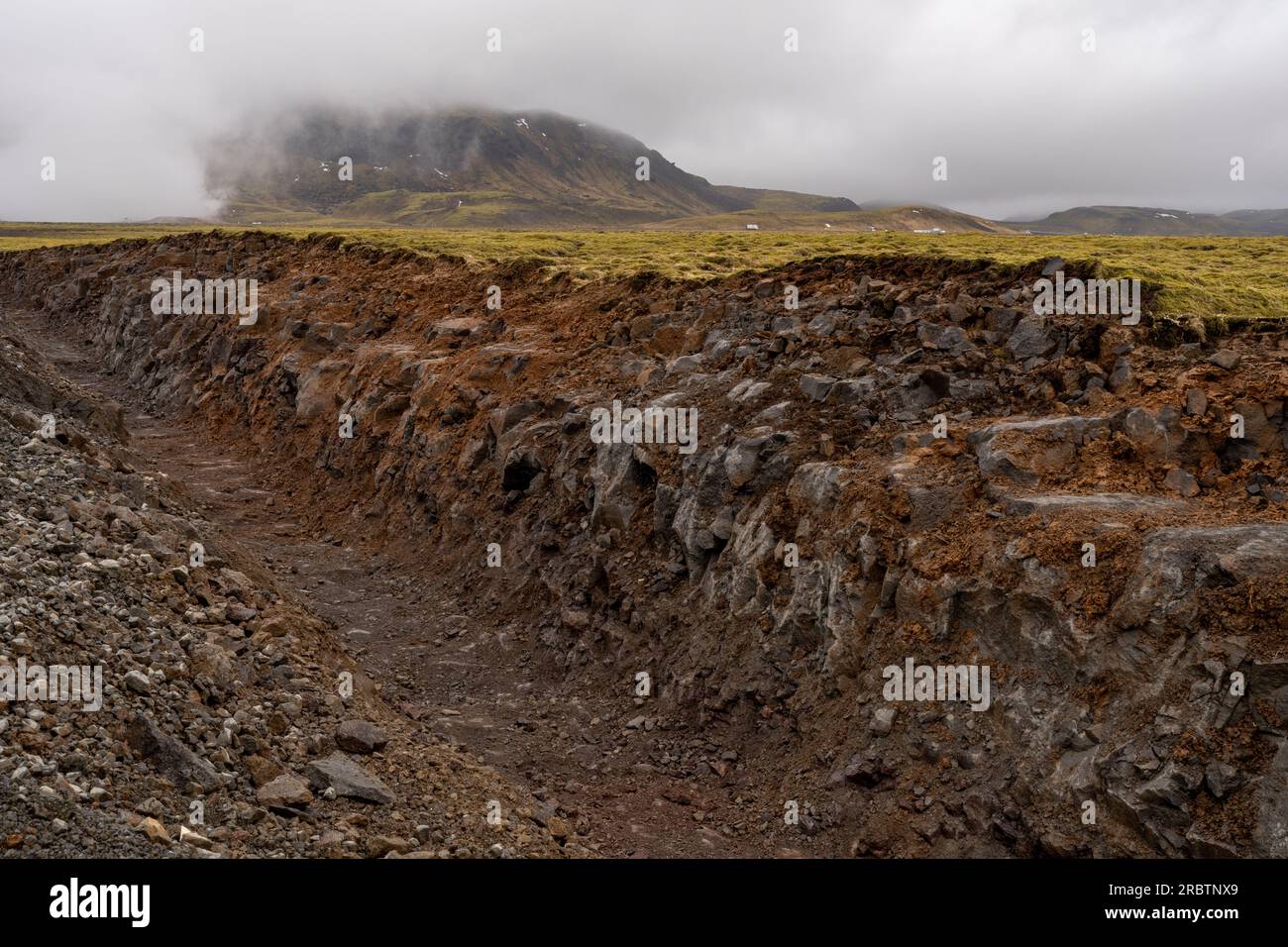 Isländische Bodenaushöhlung, die den geologischen Zeitmaßstab im Boden freilegt Stockfoto