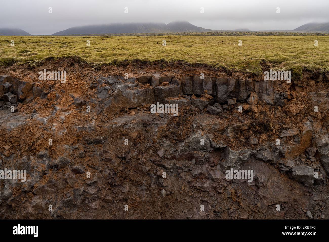 Isländische Bodenaushöhlung, die den geologischen Zeitmaßstab im Boden freilegt Stockfoto