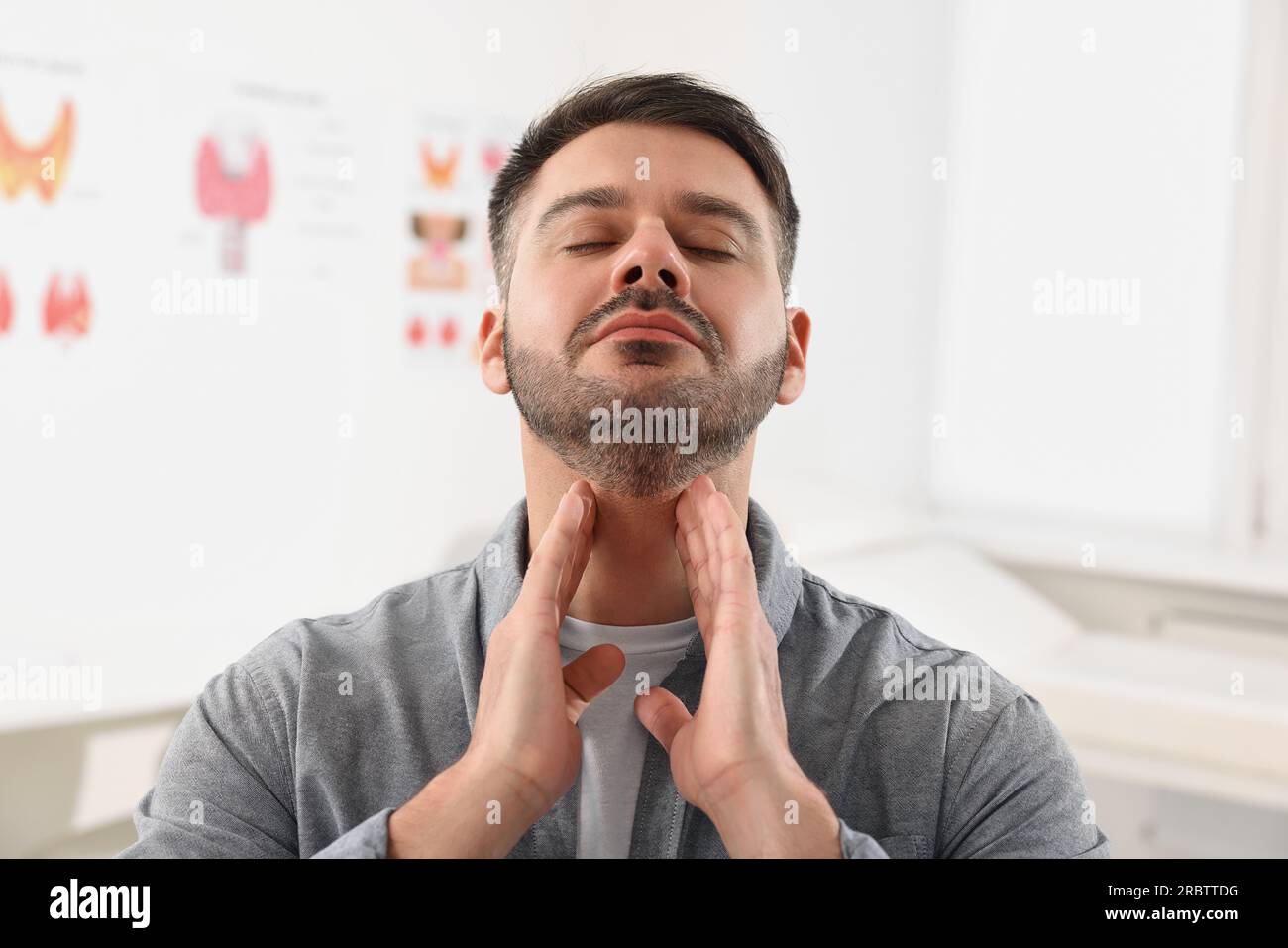 Endokrines System. Ein Mann, der sich drinnen einer Schilddrüsen-Selbstuntersuchung unterzieht Stockfoto