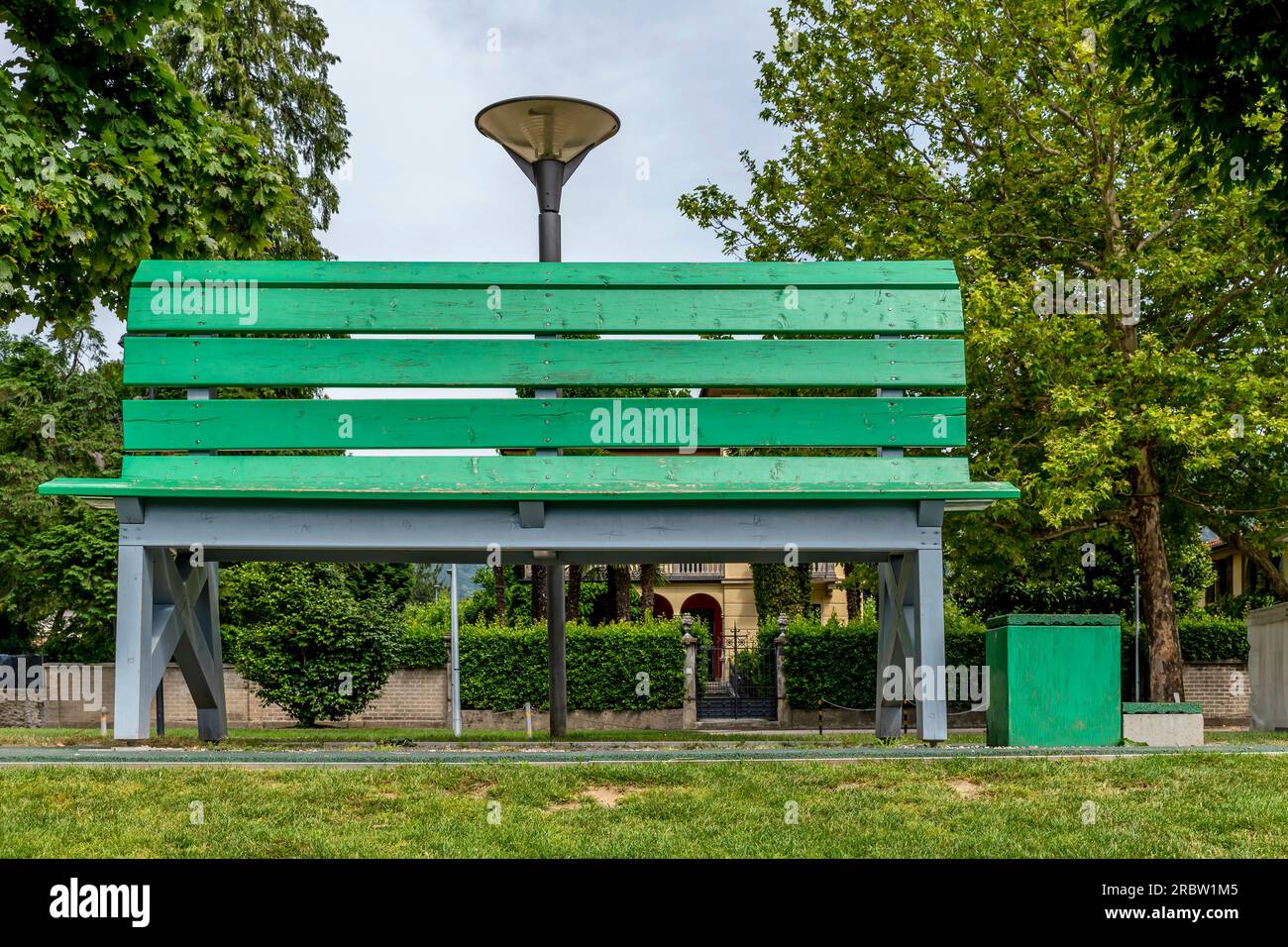 Eine riesige grüne Holzbank am Seeufer in Caslano, Lugano, Schweiz Stockfoto