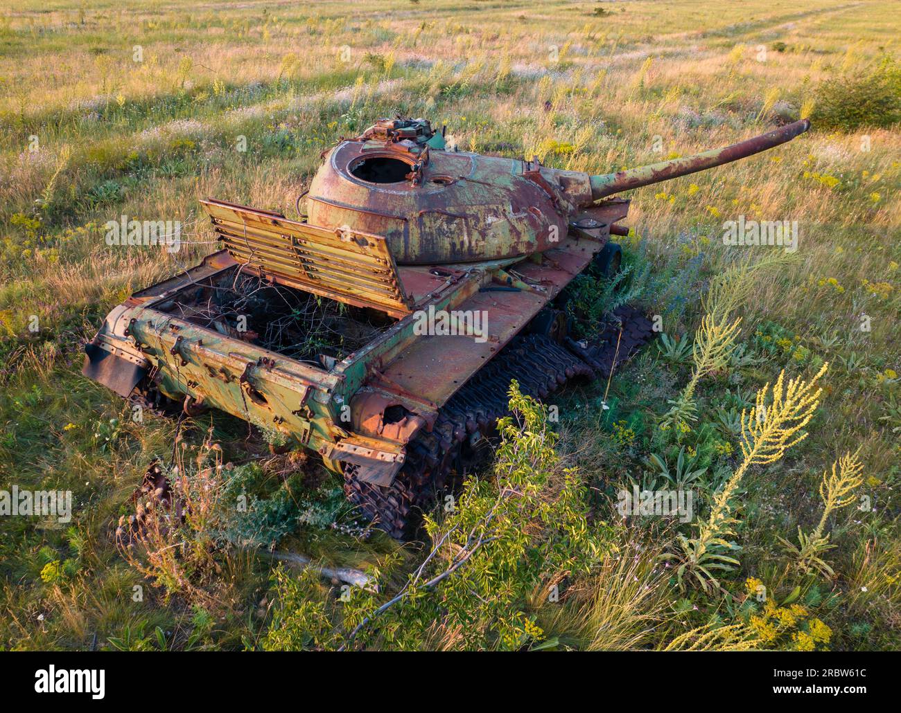 Luftaufnahme über verlassene rostige Kampfpanzer mitten auf einem landwirtschaftlichen Feld. Stockfoto