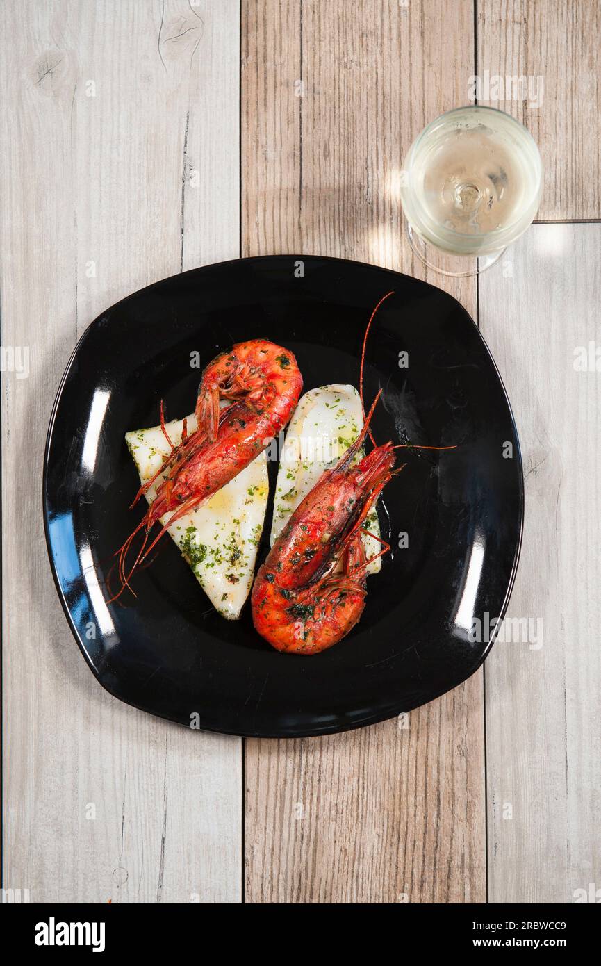 Rote Garnelen und Tintenfisch gegrillt mit Olivenöl, Knoblauch und Petersilie und Weißwein Stockfoto