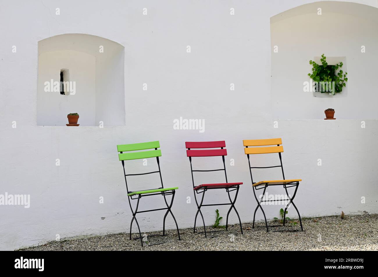 Schallaburg, Niederösterreich, Österreich. 04. Juli 2023. Die Stühle sind in verschiedenen Farben im Schallaburg Stockfoto