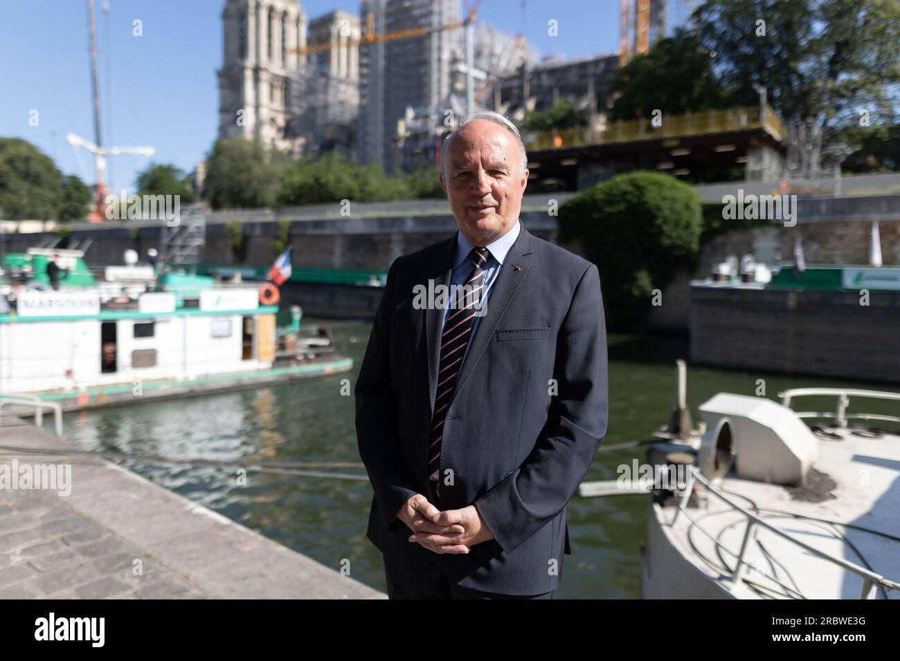 Jean-Louis Georgelin, ehemaliger Stabschef der Armeen, Der Geschäftsführer der öffentlichen Einrichtung, die für die Erhaltung und Restaurierung der Kathedrale Notre-Dame de Paris zuständig ist, stellt sich neben Notre Dame wie ein Boot auf der seine dar, das die Holzfäden transportiert, die während der Restaurierung der Kathedrale nach einem Großbrand vor 4 Jahren an die Kathedrale geliefert werden sollen. In Paris am 11. Juli 2023. Notre-Dame de Paris, das 2019 teilweise durch einen Brand zerstört wurde, soll Ende 2024 mit brandneuen liturgischen Möbeln in dunkelbrauner Bronze sowie 1.500 offenen Designstühlen in massiver Eiche wieder eröffnet werden. Acht oa Stockfoto
