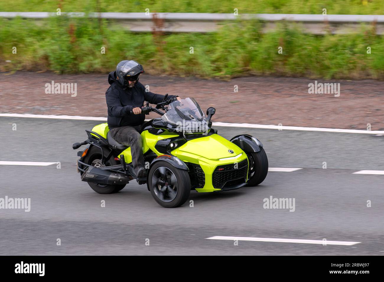 Gelber CAN-am Spyder Dreirad; Motorradfahrer; dreirädriger Transport, Motorräder, Fahrzeug, 3 Radfahrräder, 3 Radfahrer, Dreirad, 3 Radmotorräder, Motorräder, dreirädrige Motorradrouten, Fahrradfahrer, die auf der Autobahn M6 Chorley, Großbritannien fahren Stockfoto