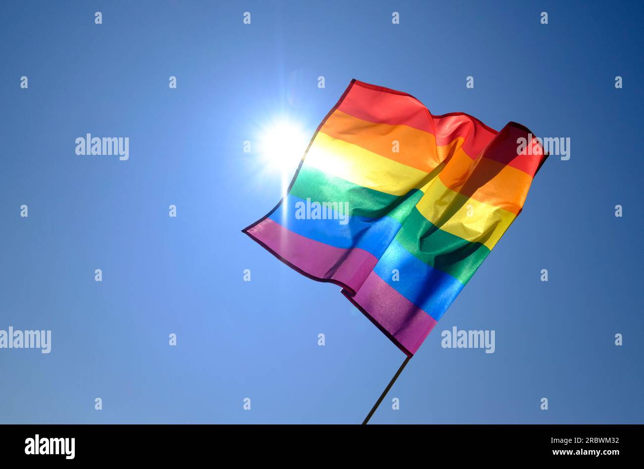 die rainbow-Flagge des homosexuellen-Stolzes auf blauem Hintergrund Stockfoto