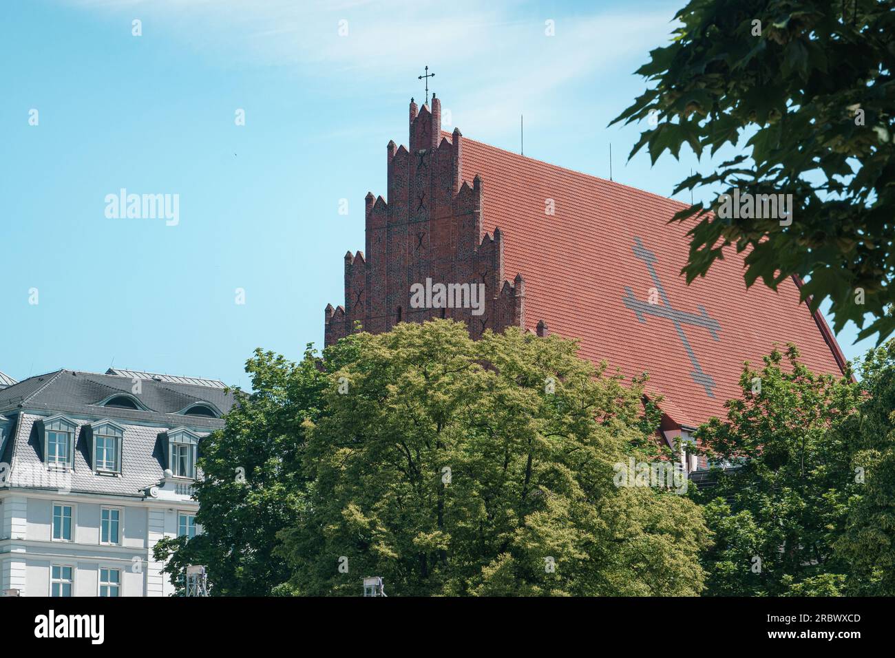 Dach der Kirche St. Stanislaus in Breslau. Gekacheltes gotisches Dach mit Kreuz Stockfoto