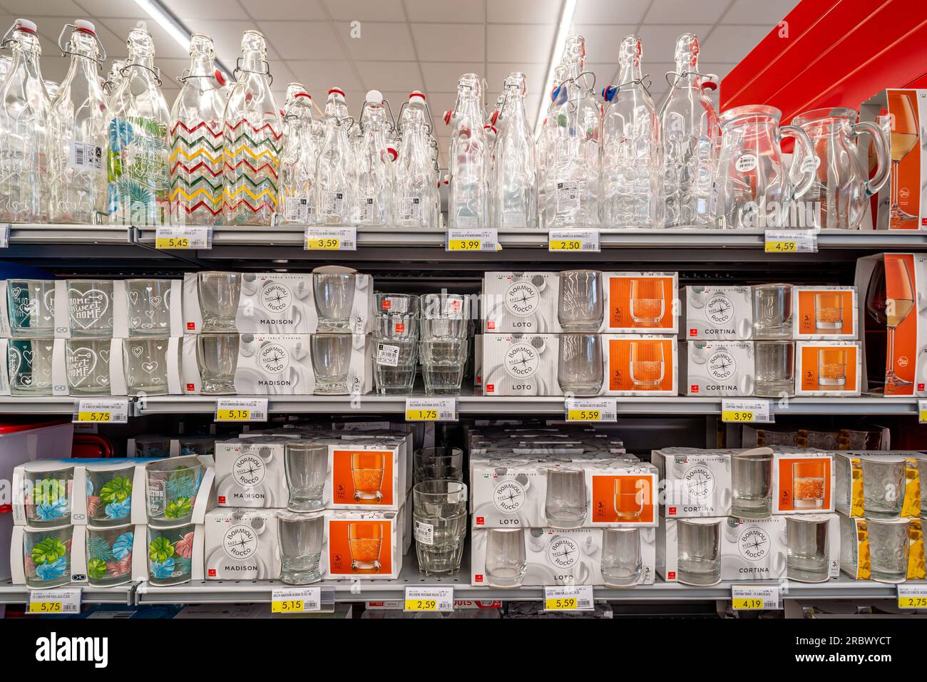 Italien - 10. Juli 2023: Glasbecher und -Flaschen verschiedener Typen und Marken, die im Regal eines italienischen Supermarkts zum Verkauf angeboten werden Stockfoto