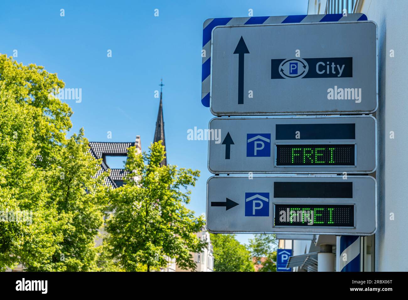 Informationstafel an der Wand eines Stadtgebäudes mit Angaben zu den kostenlosen Parkplätzen. Klarer blauer Himmel über der Stadt. Stockfoto