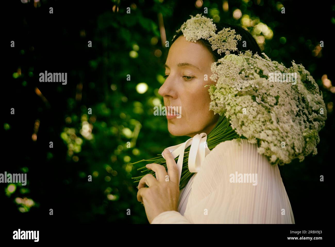 Frau in weißer Bluse mit Blumenstrauß und Stirnband IV Stockfoto