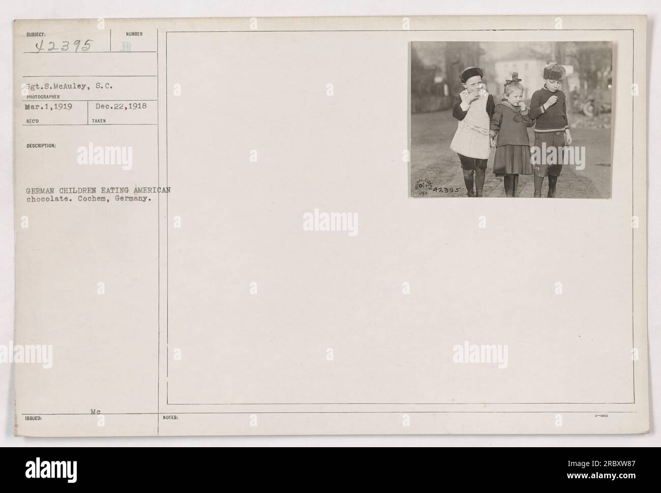 Deutsche Kinder in Cochem, Deutschland, genießen amerikanische Schokolade, die von Sgt.8 vertrieben wird. McAuley, 8.c., am 1. März 1919. Dieses Foto wurde während des Ersten Weltkriegs aufgenommen und zeigt den Einfluss amerikanischer Militäraktivitäten auf die Bereitstellung von Hilfe und den Aufbau von Verbindungen zur lokalen Bevölkerung. Stockfoto