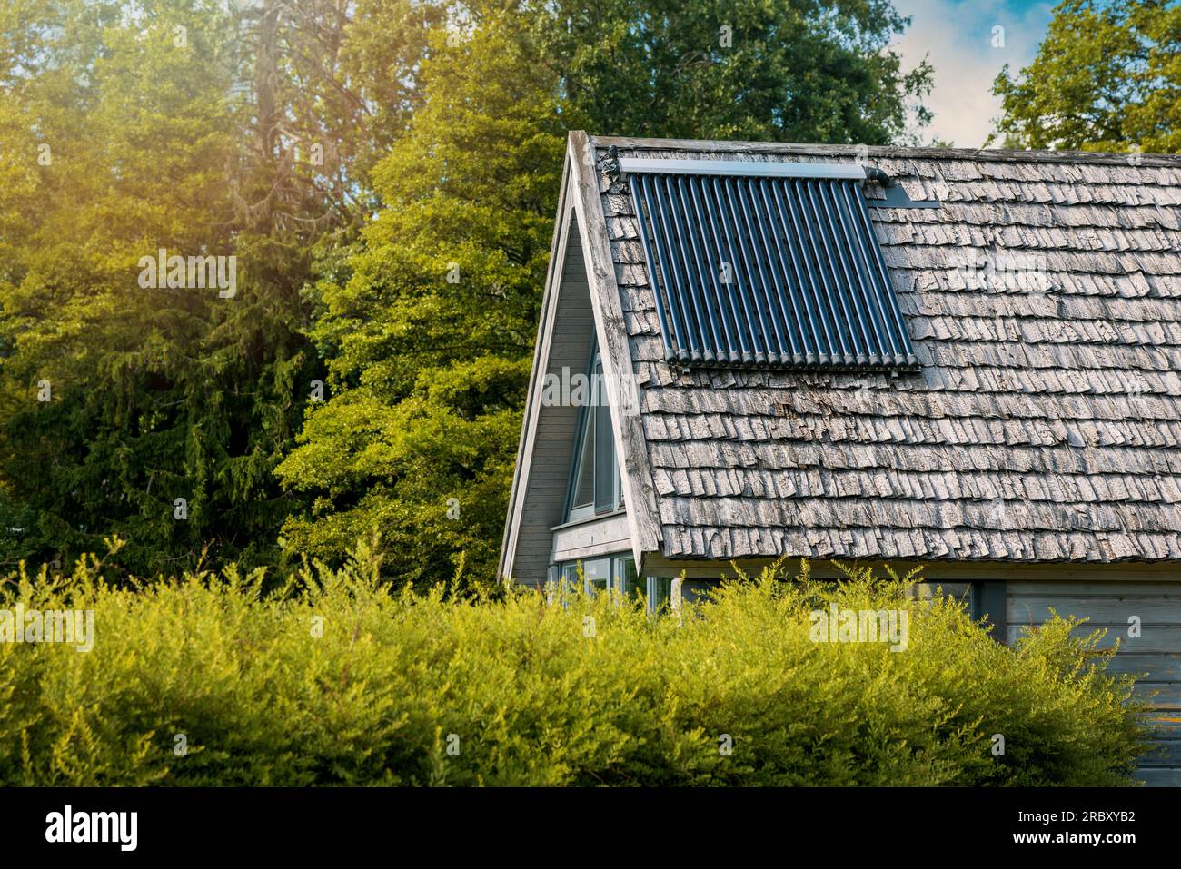 Solarbetriebener Warmwasserbereiter auf dem Hausdach. Evakuierter Röhrensammler Stockfoto