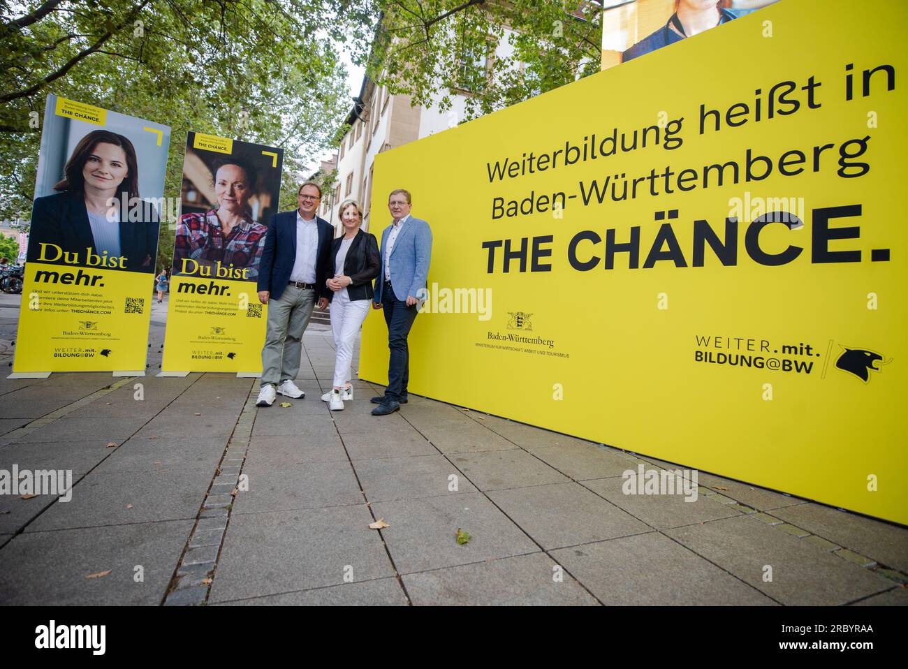 Stuttgart, Deutschland. 11. Juli 2023. Zum Start der Informations- und Werbekampagne "The Chänce" standen Kai Burmeister (l-r), Vorsitzender des DGB Baden-Württemberg, Nicole Hoffmeister-Kraut (CDU), Wirtschaftsministerin von Baden-Württemberg, und Oliver Barta, Geschäftsführer des Dachverbands Unternehmer Baden-Württemberg, an der Werbeschauer für das Projekt am Schuttgspart. Kredit: Christoph Schmidt/dpa/Alamy Live News Stockfoto