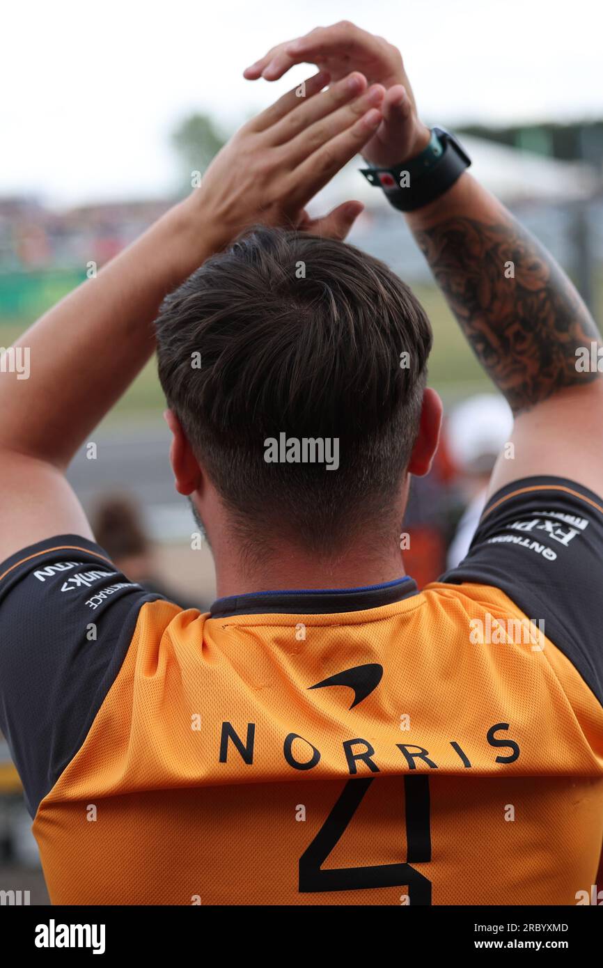 Ein Grand-prix-Fan trägt ein Trikot mit dem Namen Lando Norris (GBR) vom McLaren F1 Team und klatscht, während Lando Norris (GBR) vom McLaren F1 Team seinen besteht Stockfoto
