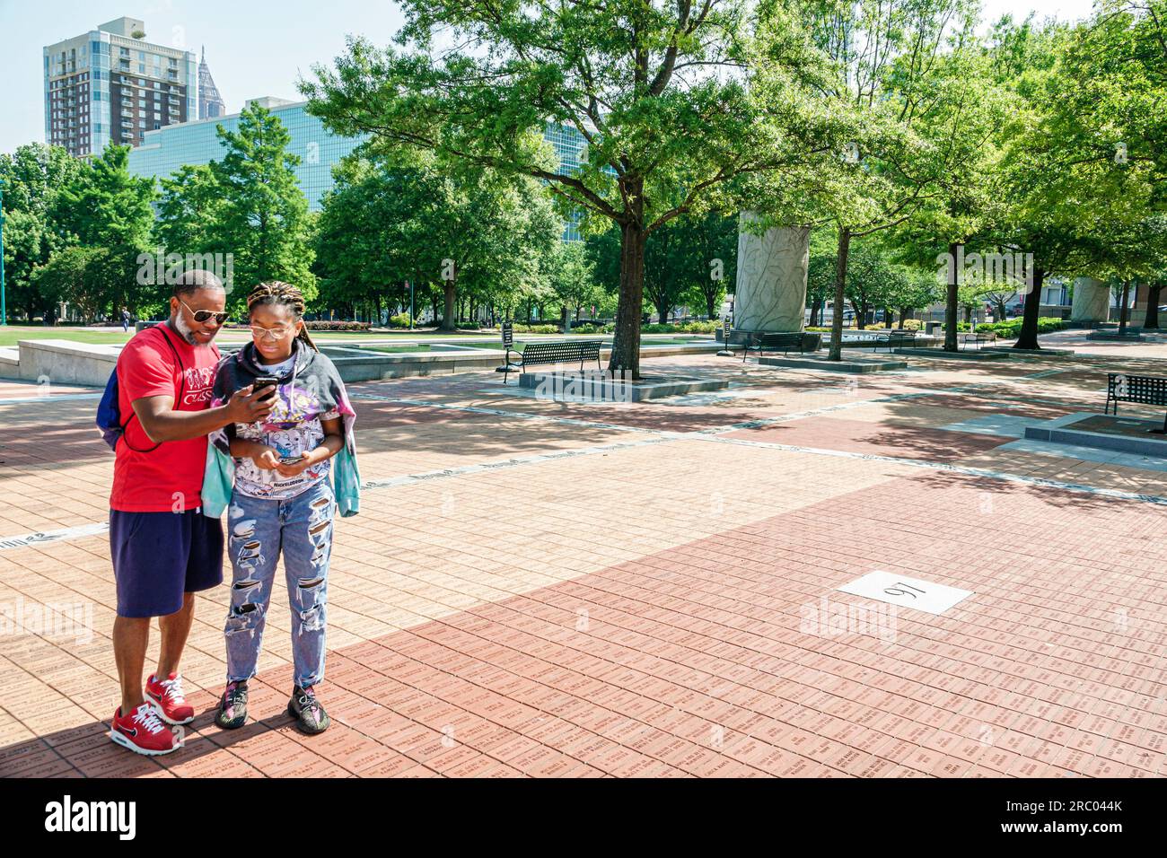 Atlanta Georgia, Centennial Olympic Park, ein schwarzafroamerikanisches Paar, eine Frau, die sich ein Smartphone-Foto ansieht Stockfoto