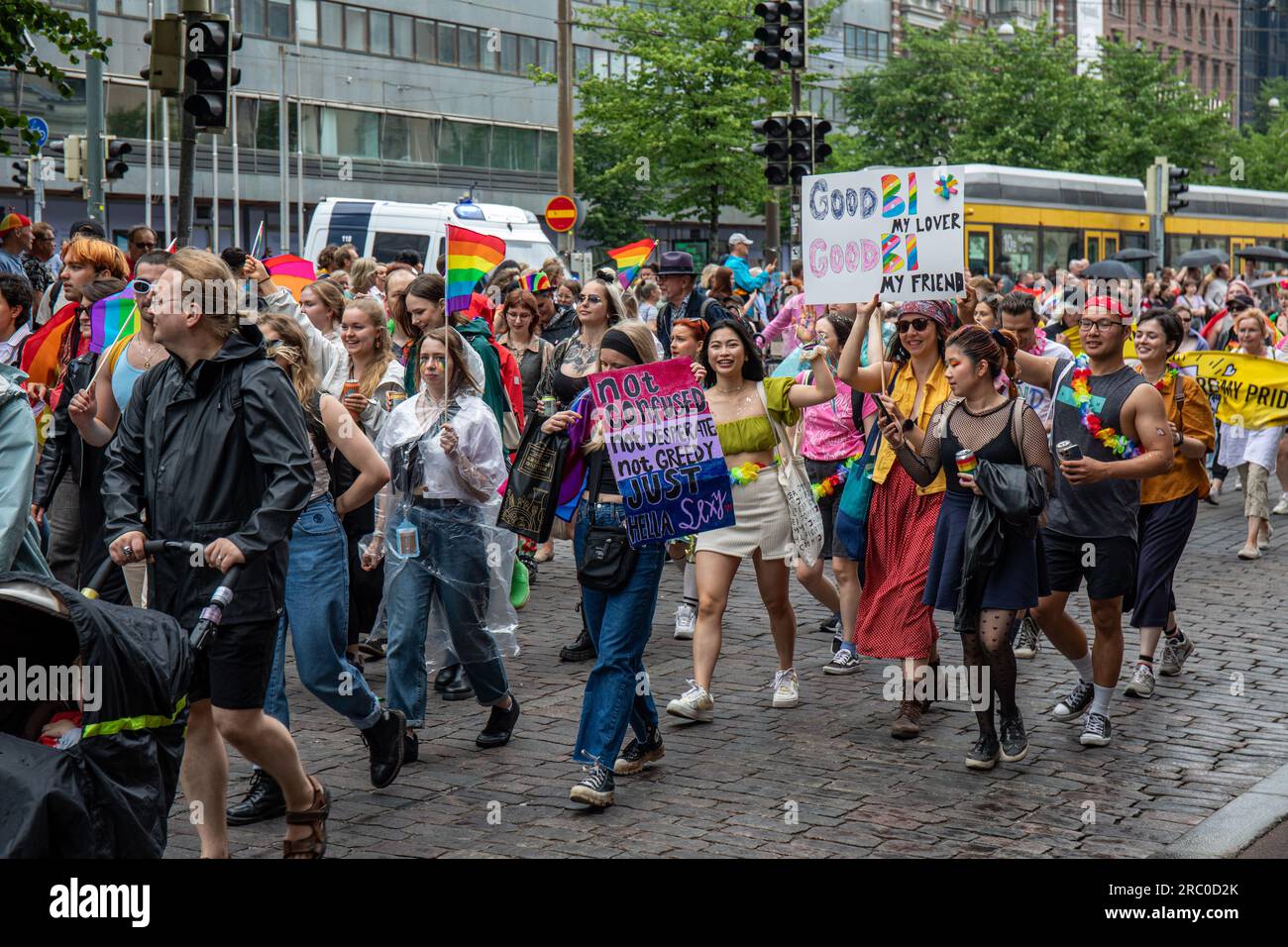 Menschen marschieren mit handgefertigten Schildern auf der Helsinki Pride 2023 Parade an einem Regentag in Helsinki, Finnland Stockfoto
