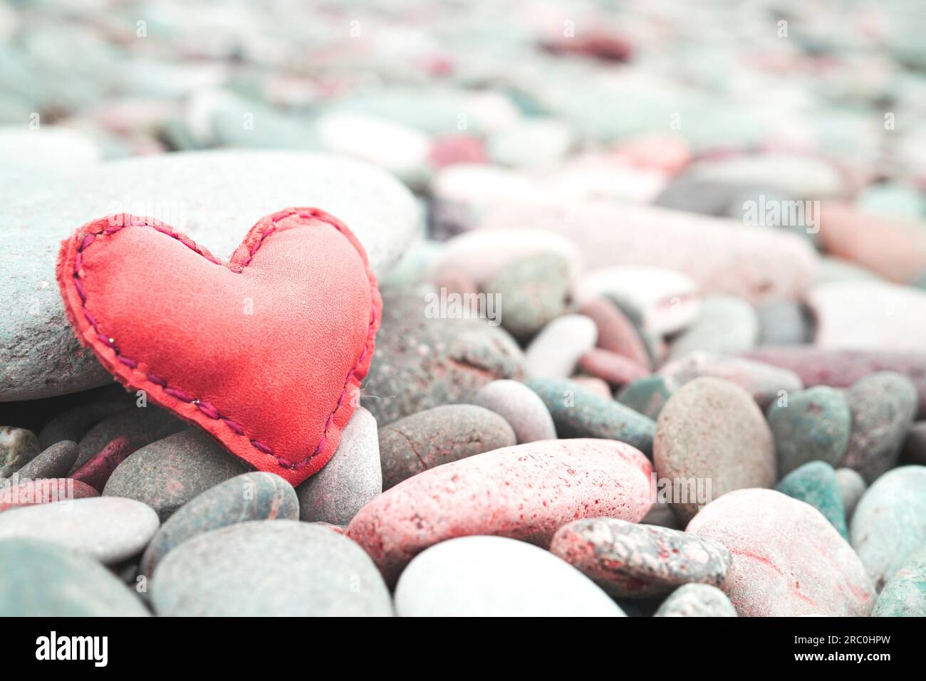 Rotes Lederherz auf Kieselstein Still Life für Hintergrund und Inspiration Stockfoto