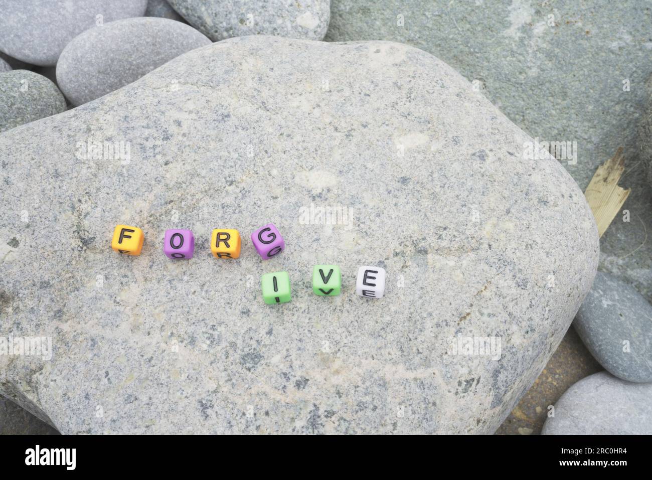 Verzeihen Sie das Wort auf Kieselstein für Hintergrund und Inspiration Stockfoto