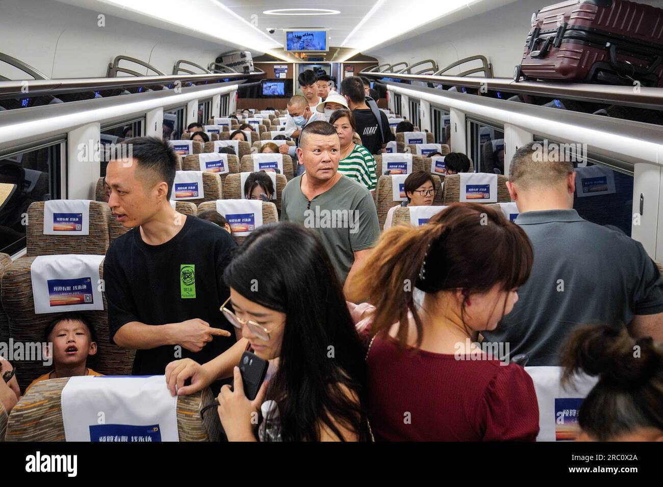 Shenzhen, Guangdong, China. 11. Juli 2023. Die Leute gehen, während sie im Zug sitzen. Die Hochgeschwindigkeitsbahn ist ein beliebter und erschwinglicher öffentlicher Übergang für Reisen zwischen Städten und Provinzen auf dem chinesischen Festland. Zu Beginn der Sommerferien nehmen viele Menschen die Hochgeschwindigkeitsbahn, um innerhalb Chinas zu reisen, viele von ihnen bringen auch ihre Familien und Kinder mit. (Kreditbild: © Michael Ho Wai Lee/SOPA Images via ZUMA Press Wire) NUR REDAKTIONELLE VERWENDUNG! Nicht für den kommerziellen GEBRAUCH! Stockfoto