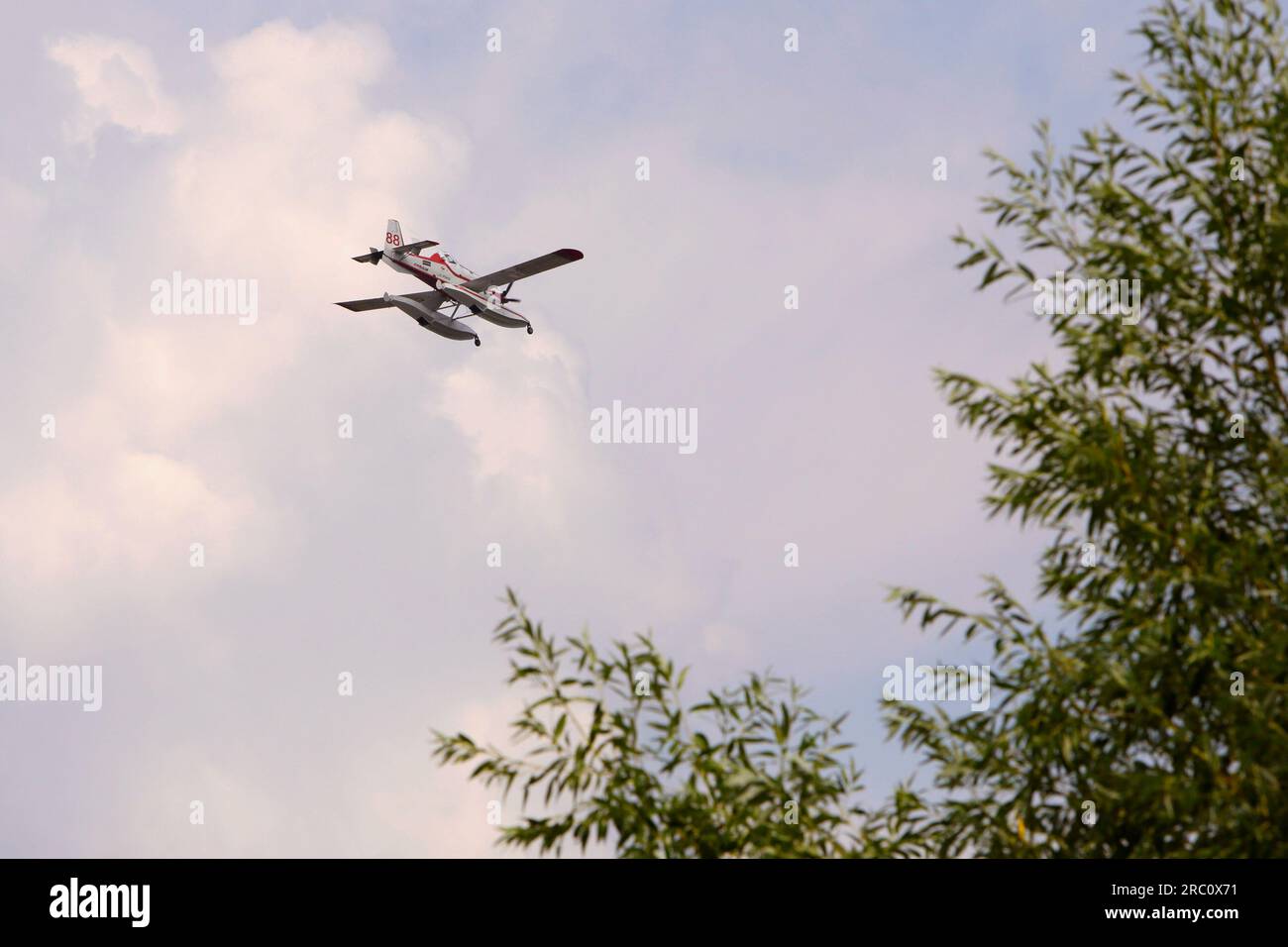 Smithers BC.- Juli 09 2023 - eines von bis zu sieben Flugzeugen, die am Wochenende Waldbrände in der Nähe von Smithers bekämpfen, fliegt tief über Baumkronen. Stockfoto