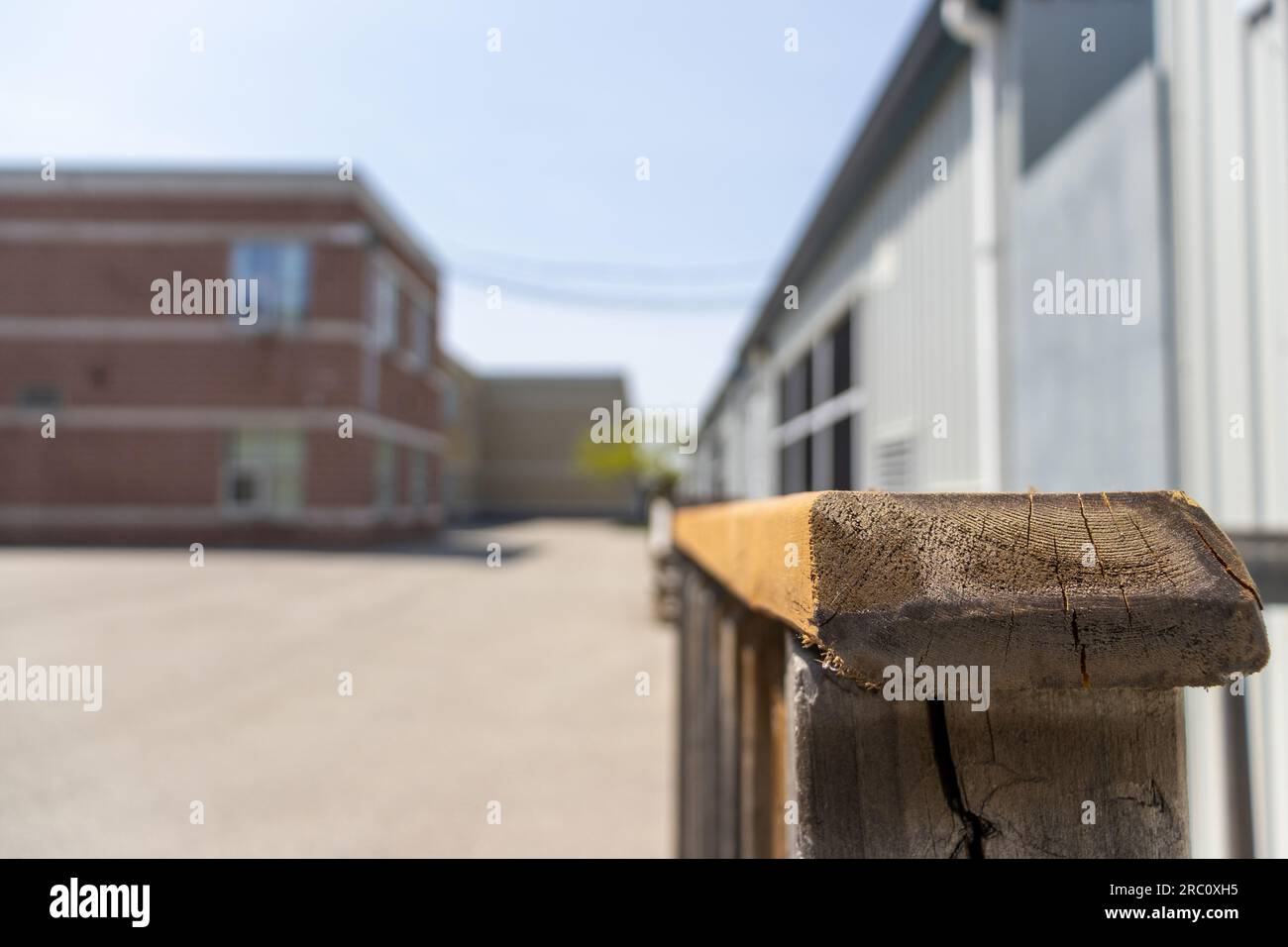 Schulaußenseite Tragbarer Handlauf aus Holz draußen - Nahaufnahme - verschwommener Hintergrund. Aufgenommen in Toronto, Kanada. Stockfoto
