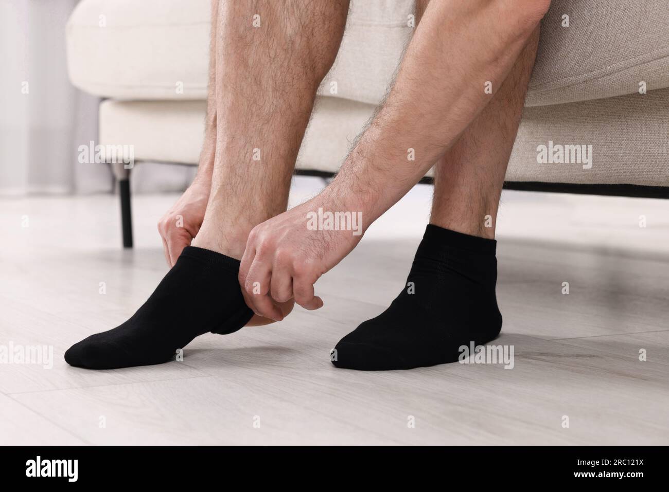 Ein Mann, der zu Hause schwarze Socken anzieht, Nahaufnahme Stockfoto