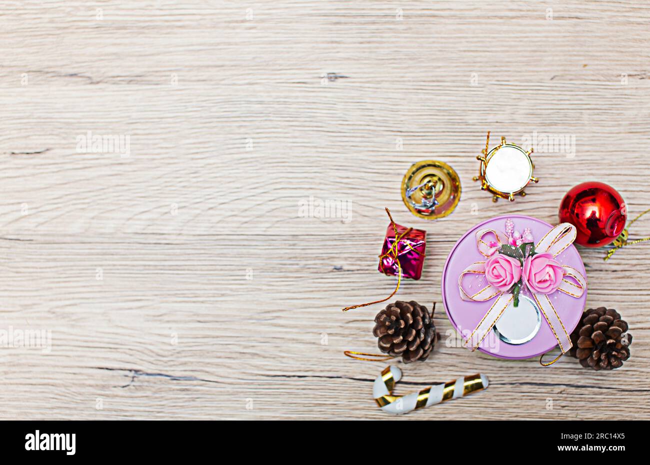 Weihnachtliche Geschenkboxen mit Blick aus dem hohen Winkel auf rustikalem Holzfußboden. Die Geschenke sind an den Rändern des Rahmens verstreut, sodass etwas Platz bleibt Stockfoto