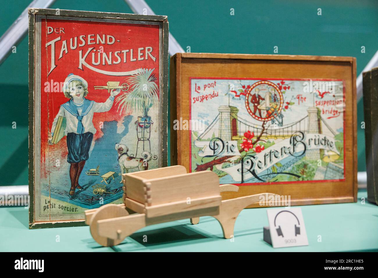 Iphofen, Deutschland. 11. Juli 2023. Das hölzerne Bauset „der tausend Künstler“ (um 1900) mit Holzbauelementen, aus denen die Schubkarre im Vordergrund gebaut wurde, ist in der Sonderausstellung „Diversity of the Standard - Construction sets through the Century“ im Knauf Museum zu sehen. Die interaktive Vorstellung, die am 16. Juli beginnt, ist der 200-jährigen Geschichte der Bausätze gewidmet. Kredit: Daniel Karmann/dpa/Alamy Live News Stockfoto