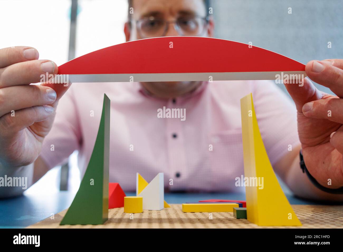 Iphofen, Deutschland. 11. Juli 2023. Markus Mergenthaler, Leiter des Knauf Museums Iphofen, präsentiert die Holzkonstruktion mit dem „Spiel für kleine Schiffe“ der Naef Spiele AG aus dem Jahr 2023 in der Sonderausstellung „Diversity of the Standard - Construction Sets through the Century“. Der Gebäudekomplex stellt sich seit 1923 unverändert dar. Die interaktive Vorstellung, die am 16. Juli beginnt, ist der 200-jährigen Geschichte der Bausätze gewidmet. Kredit: Daniel Karmann/dpa/Alamy Live News Stockfoto