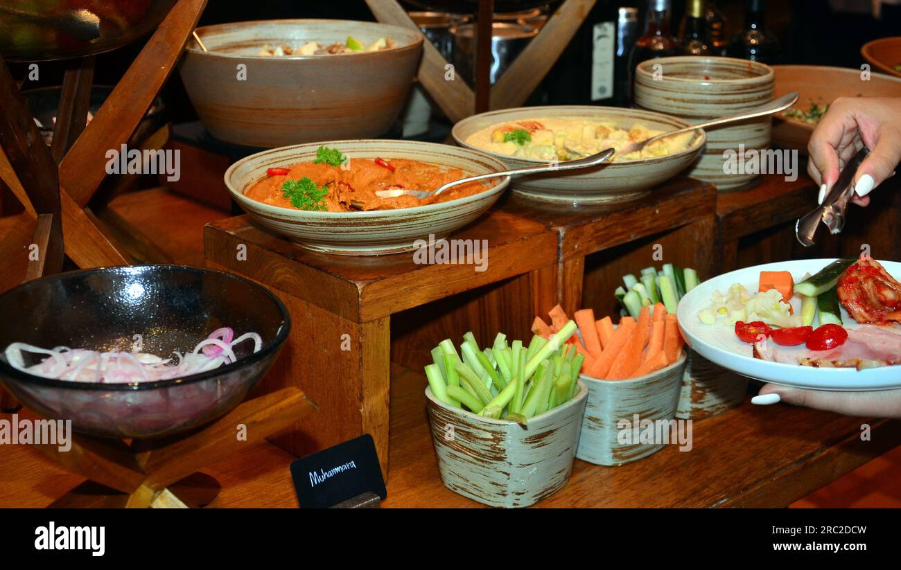 Eine Person wählt aus einem Teil des Frühstücksbuffets im Grand Hyatt Erawan Hotel, Bangkok, Thailand Stockfoto