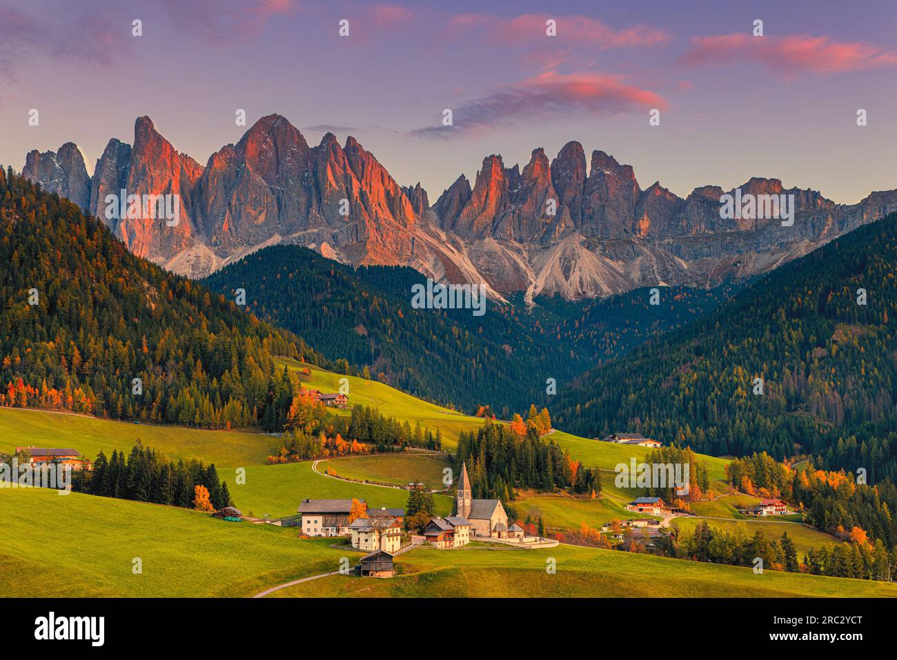 Ein Bild von einem herbstlichen Sonnenuntergang in der berühmten Kirche und dem Dorf Santa Maddalena vor den Geisler- oder Geisler-Dolomiten im Val di Stockfoto