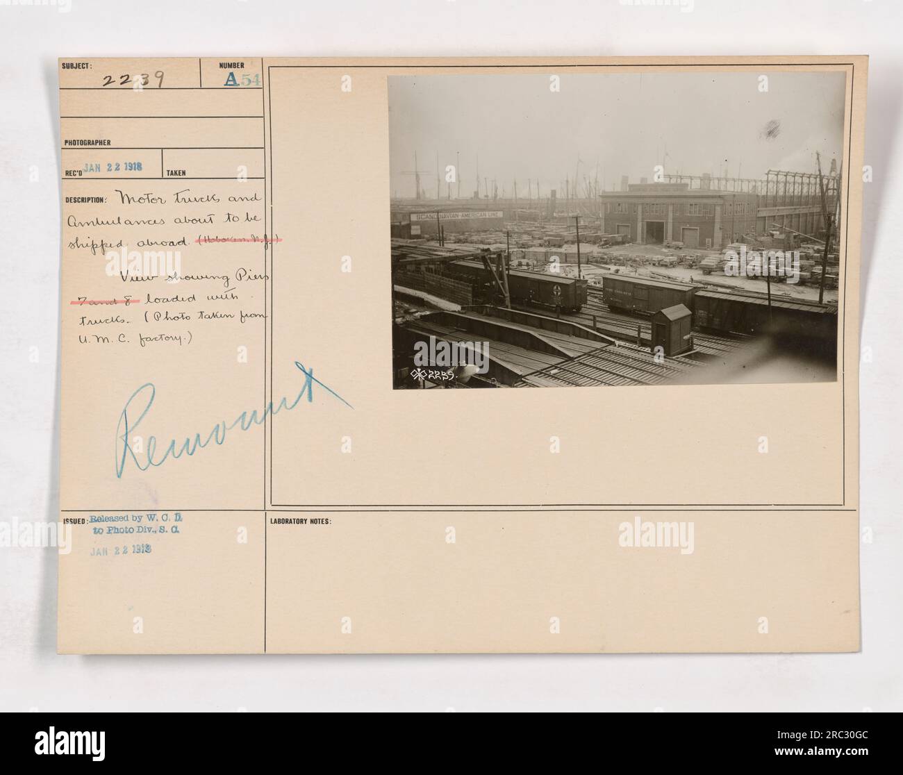 Motorwagen und Krankenwagen stehen an einem Pier und können während des Ersten Weltkriegs ins Ausland transportiert werden. Das 1918 aufgenommene Foto zeigt die geschäftige Szene mit beladenen und für den Einsatz vorbereiteten Lkws. Das Bild stammt von der U.M.C. Factory Ambulance. Stockfoto