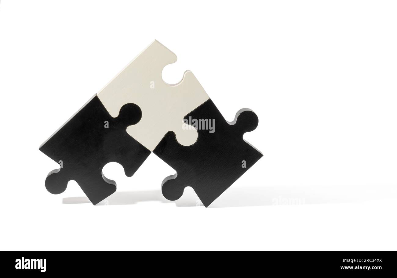 Schwarze und weiße Puzzleteile mit verschiedenen Formen, isoliert auf einfachem hellen Hintergrund Stockfoto