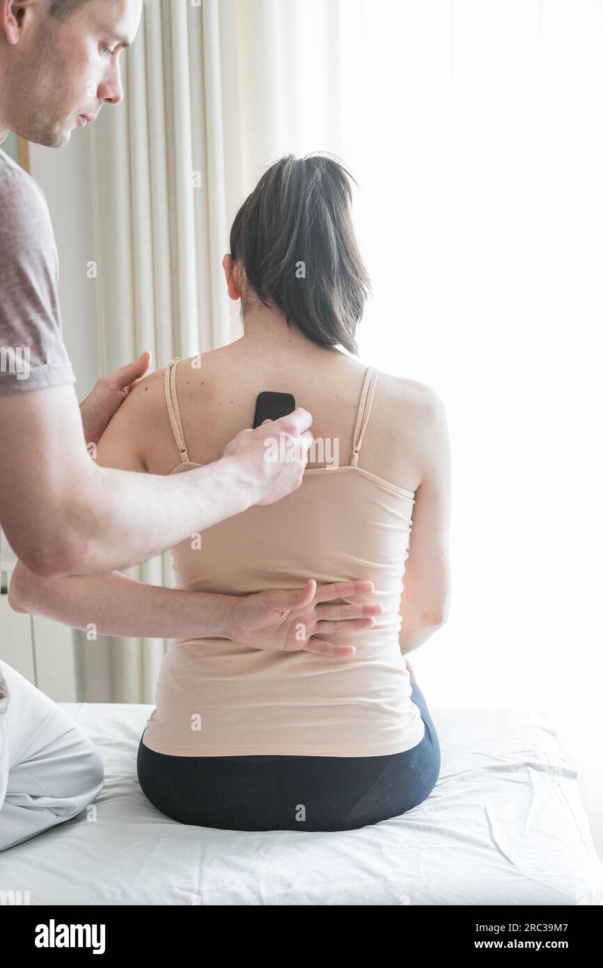 Junge Weiße, Die Eine Körperbehandlung Bekommt. Therapeut macht Hautkratztechnik. Chinesische Technik, Gua sha, zur Schmerzlinderung und -Behandlung Stockfoto