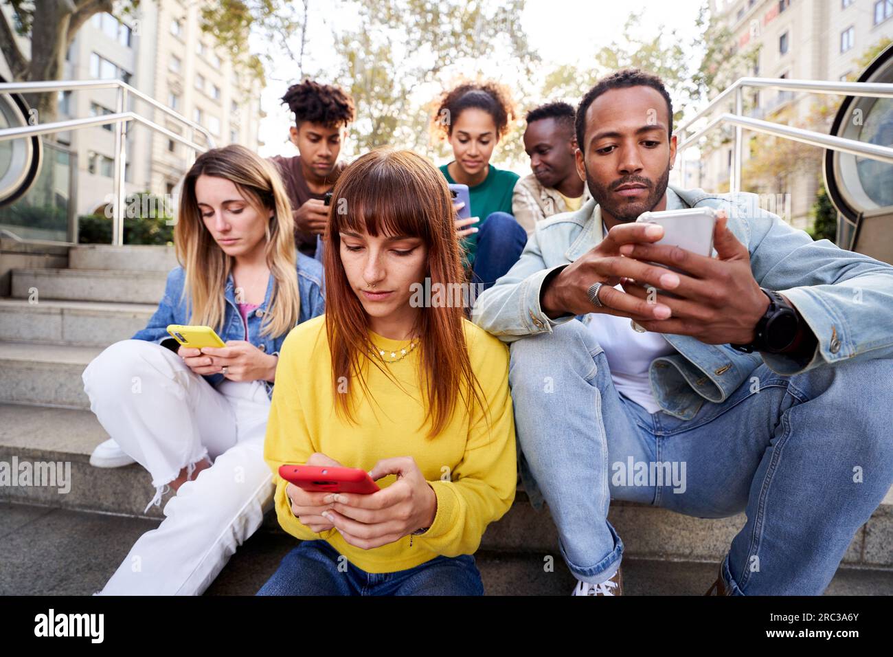 Junge Menschen, die süchtig nach sozialen Medien sind und telefonisch versammelt sind. Stockfoto